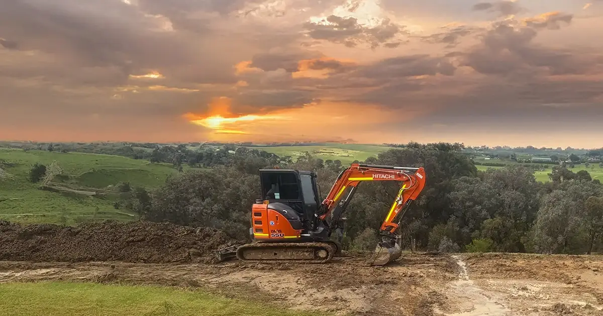 Excavator on Melbourne hillside at sunset